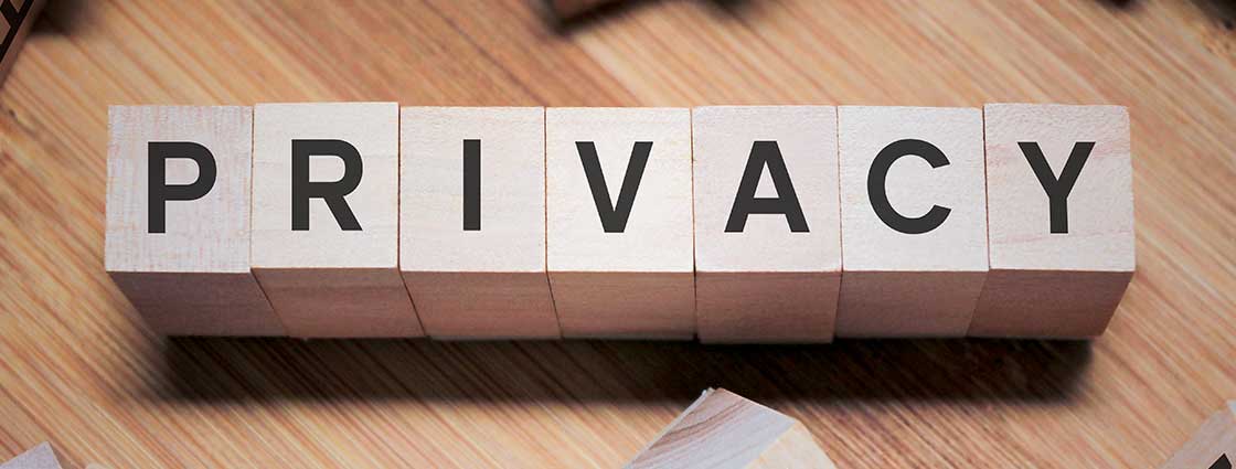Wooden blocks on wooden table spelling out 'PRIVACY'