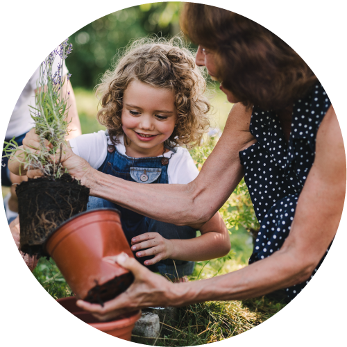 Smiling child and older woman gardening together